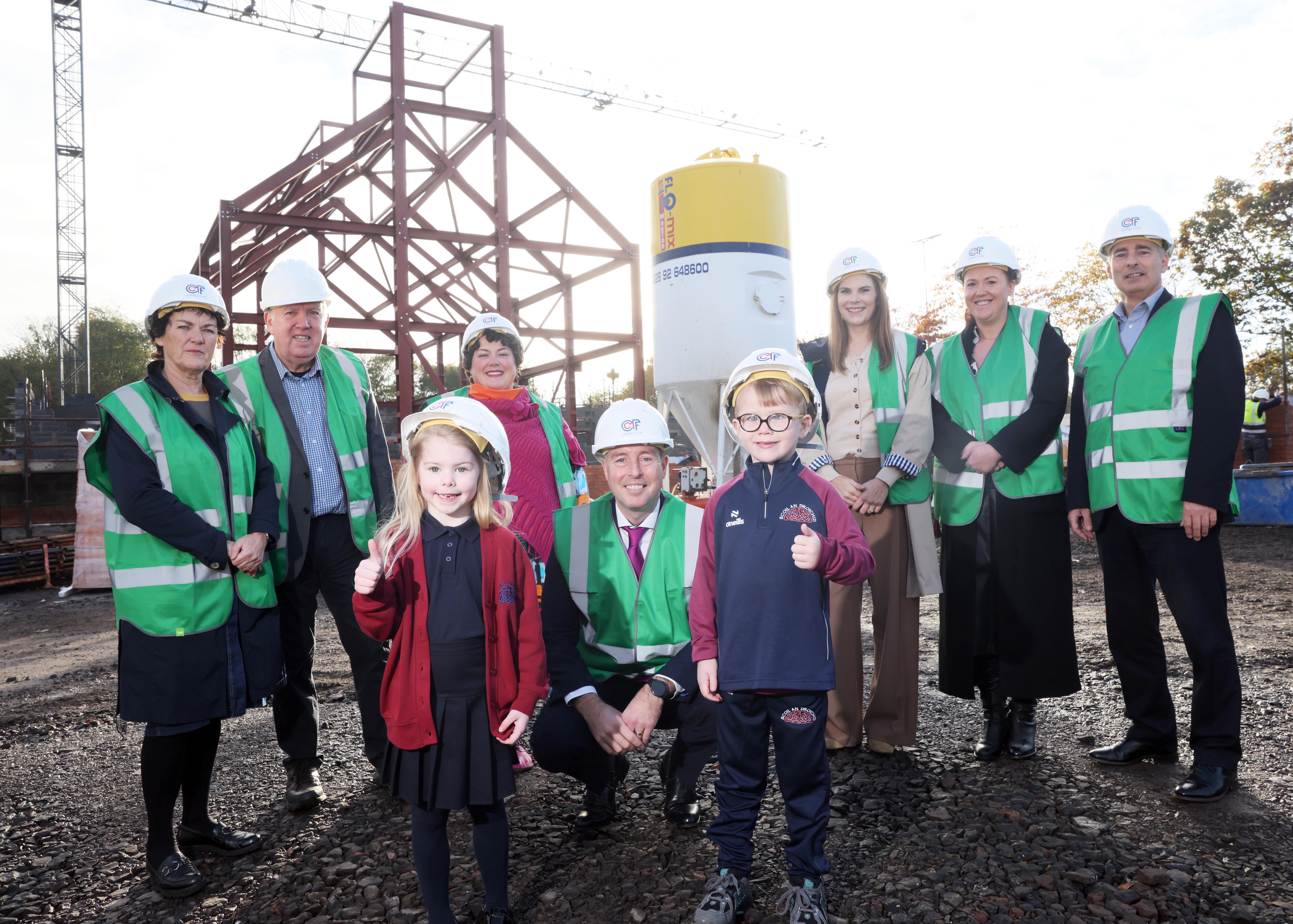Fionnguala McCotter Trustee and former Principal, Pillib Ó Ruanaidh, School Founder, Maria Thomasson, Chief Executive Comhairle Na Gaelscolaíochta,  Education Minister Paul Givan, Principal Claire Donnelly, Vice Principal Aisling Nic Giolla Bhéin, Alden Henderson, Chair Board of Governors and pupils Emer and Dualta. 