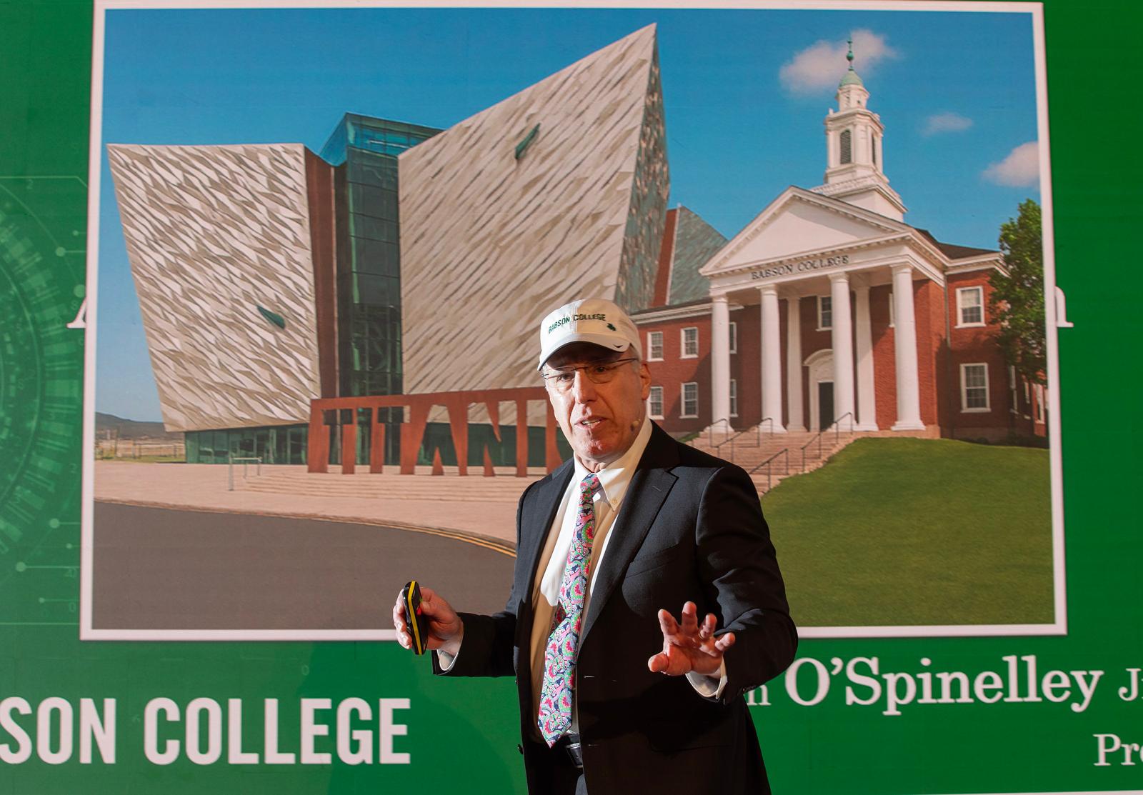 AI IMAGE: President Spinelli addressing the AICON Conference on Thursday - behind him is an image of Belfast and Babson created by artificial intelligence
