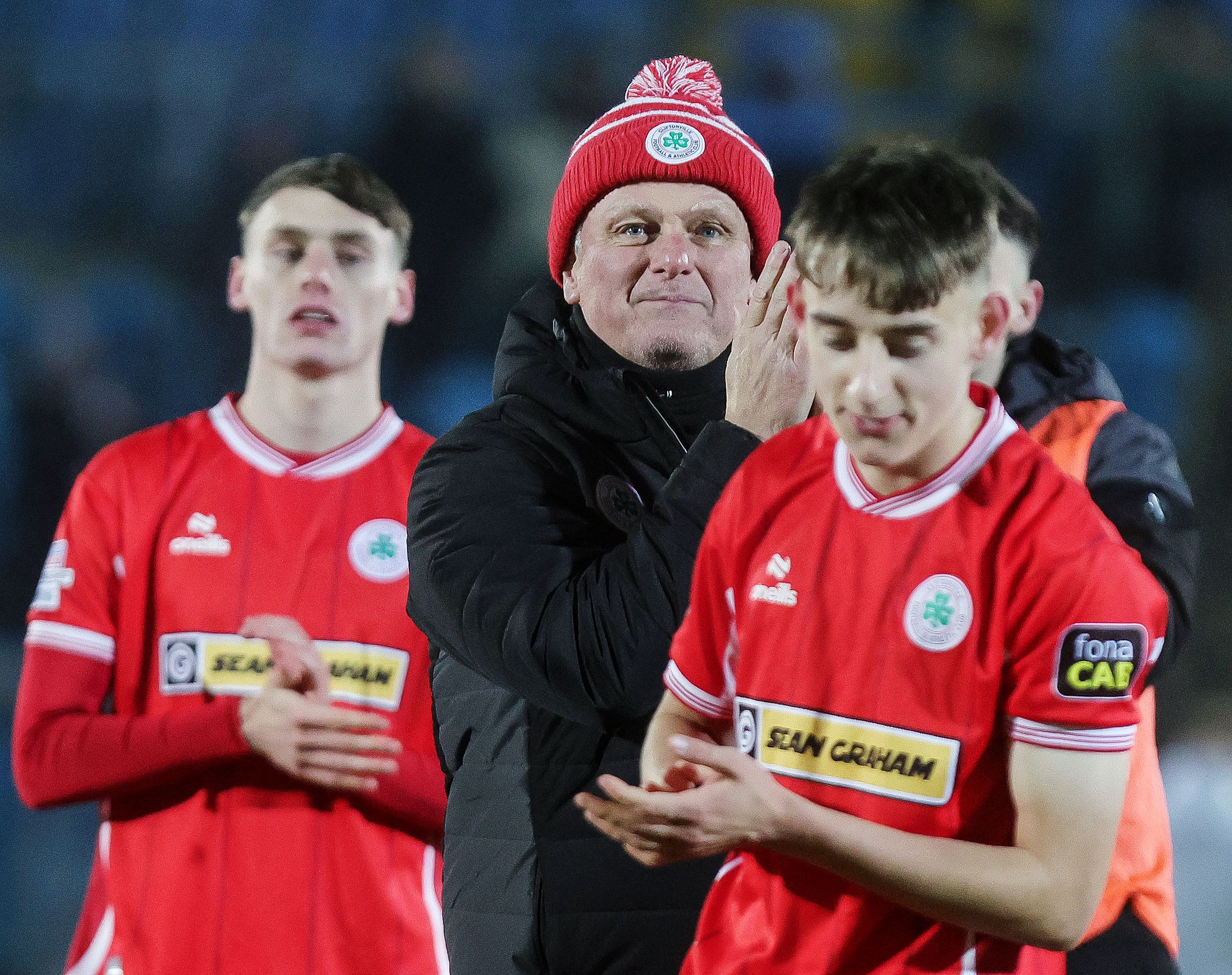 Jim Magilton celebrates with the Cliftonville away fans