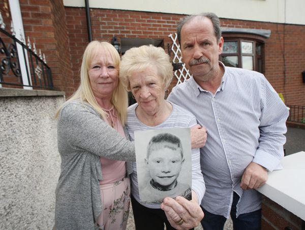 Patrick Rooney's mother Alice with her son and daughter Con and Sharon, holding a photo of Patrick back in August 2019