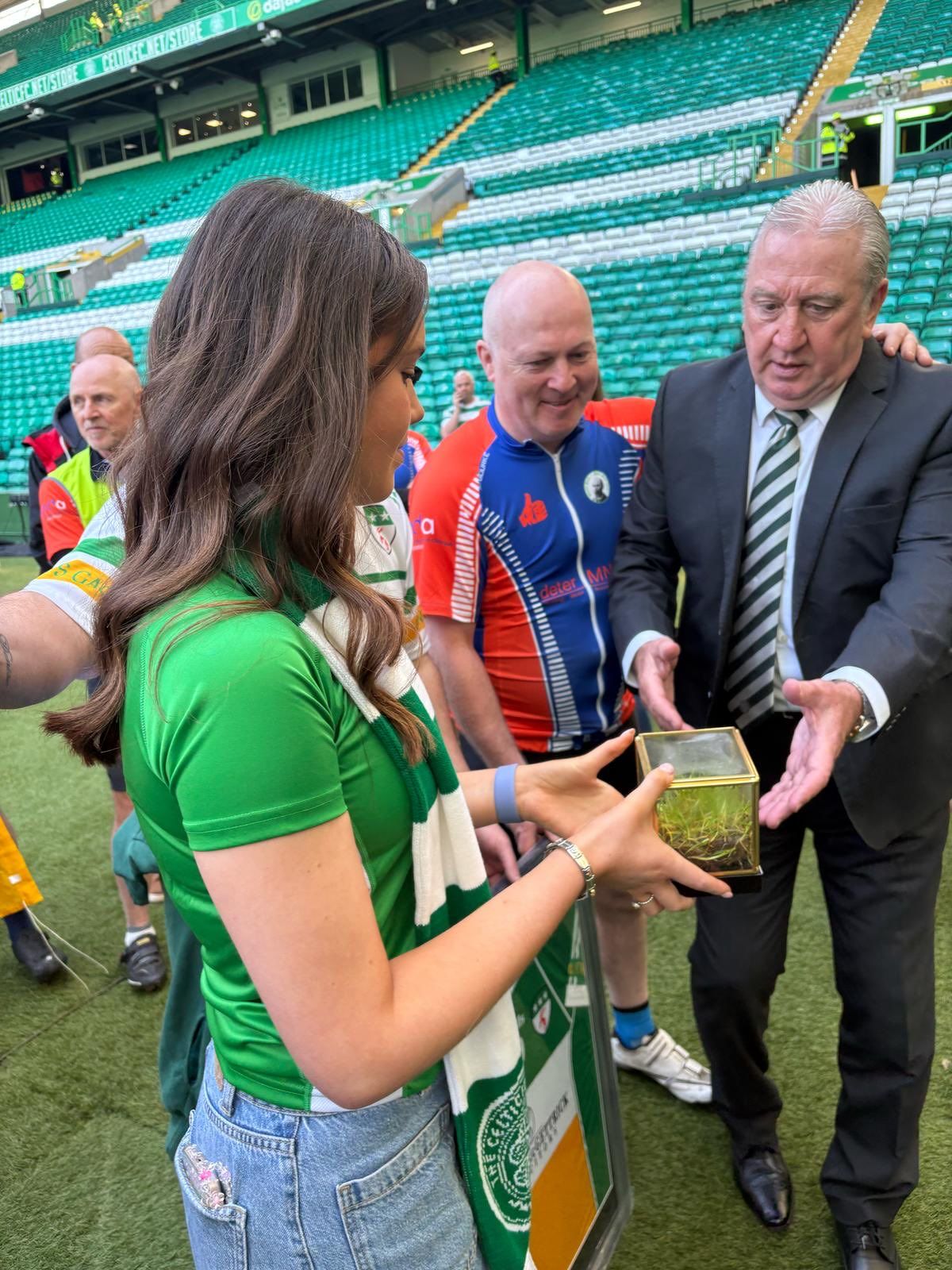 Ava Finnegan presents former Celtic captain George McCluskey with a sod of turf from the new Davitts GAC pitch