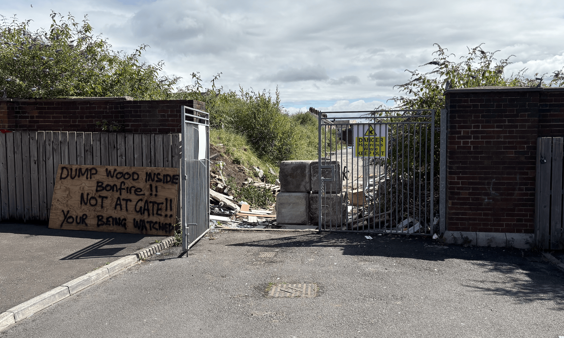 WARNING: The entrance to the bonfire site is unsecured and a handwritten sign warns that it is being watched