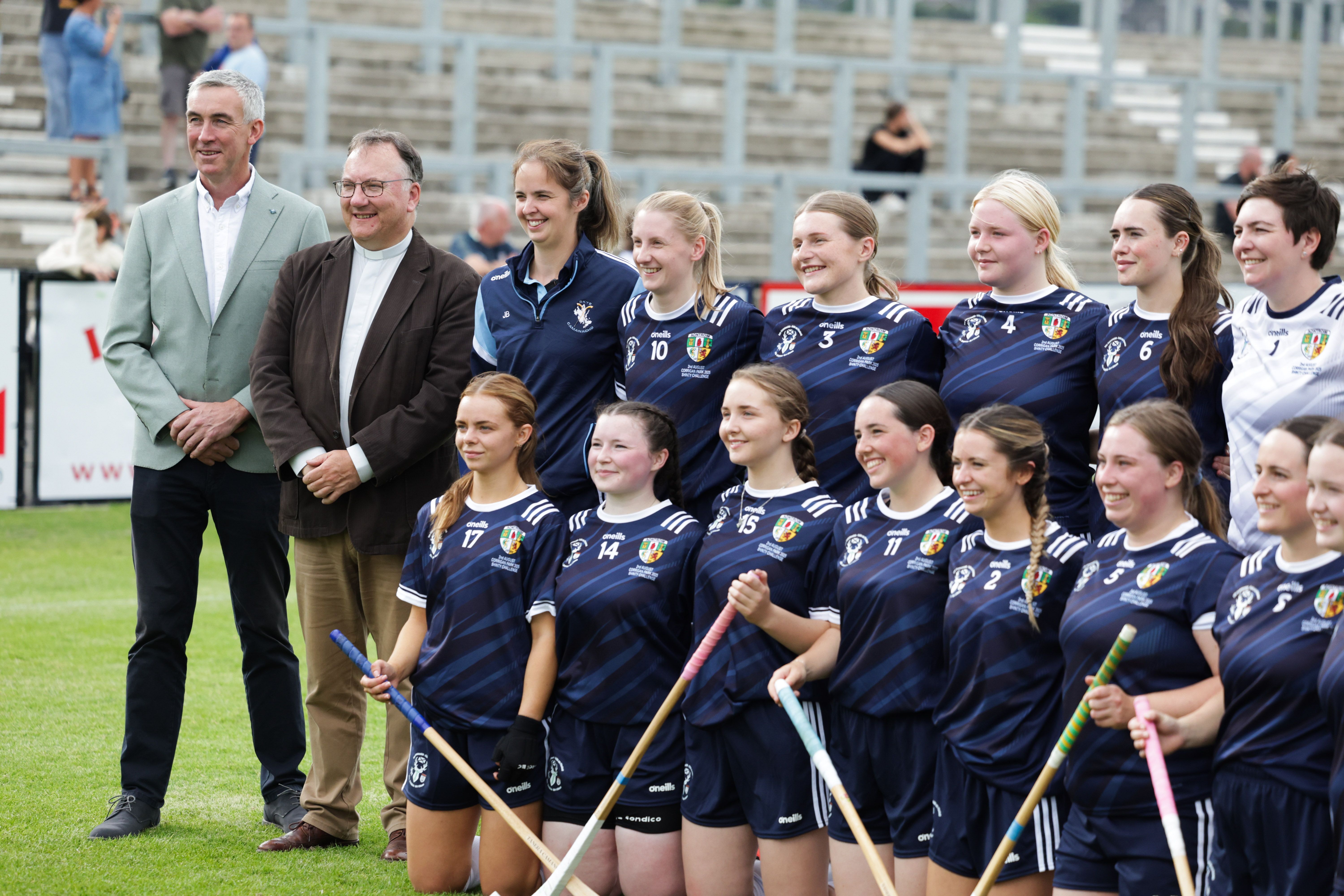 Moderator, Rt Rev Dr Trevor Gribben, and the Chair of County Antrim GAA, Seamus McMullan, with some of the ladies shinty team