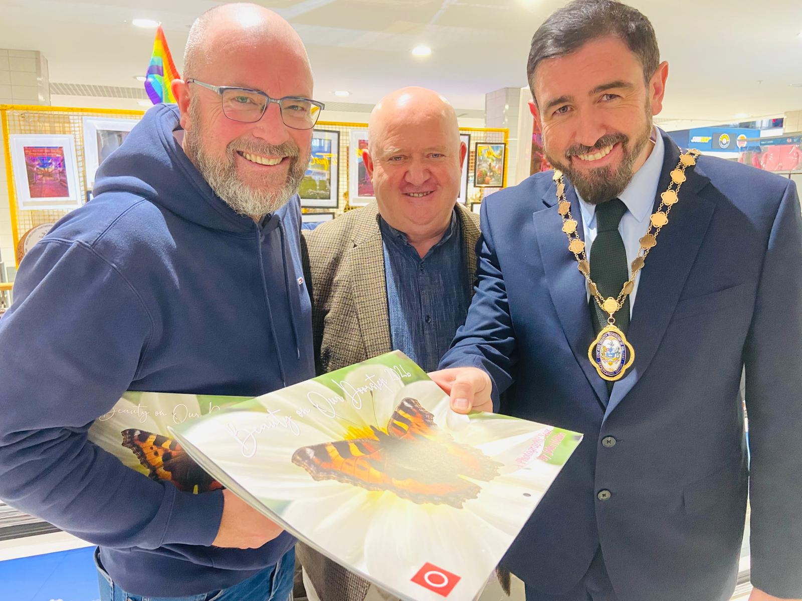 John launches his 2026 calendar with Kennedy Centre manager John Jones and Deputy Lord Mayor Paul Doherty