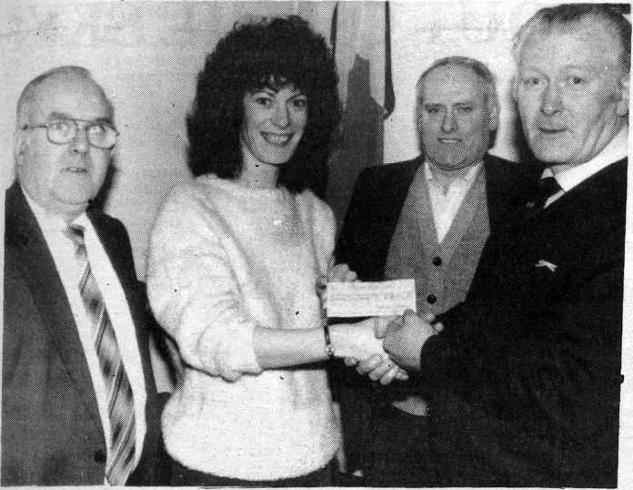PRESENTATION: Liam Higgins, Chairman of the Roddy McCorley Society, presents a cheque on behalf of the Society to Teresa Holland for the POWs' Week held before Christmas 1984. Committee members also pictured are Michael McMorrow and John Mcllkenny