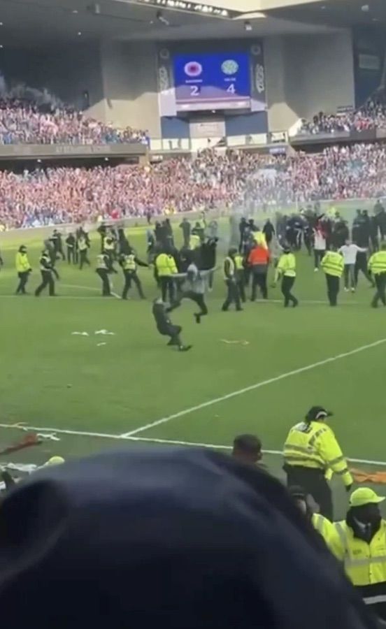 DROP KICK: A young Rangers fan kicks a rival fan to the ground in the Celtic penalty box