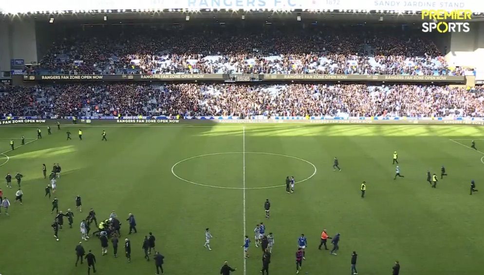 RELAXED: Rangers players leaving the pitch and in relaxed conversation as a Rangers fan is subdued in the Celtic half