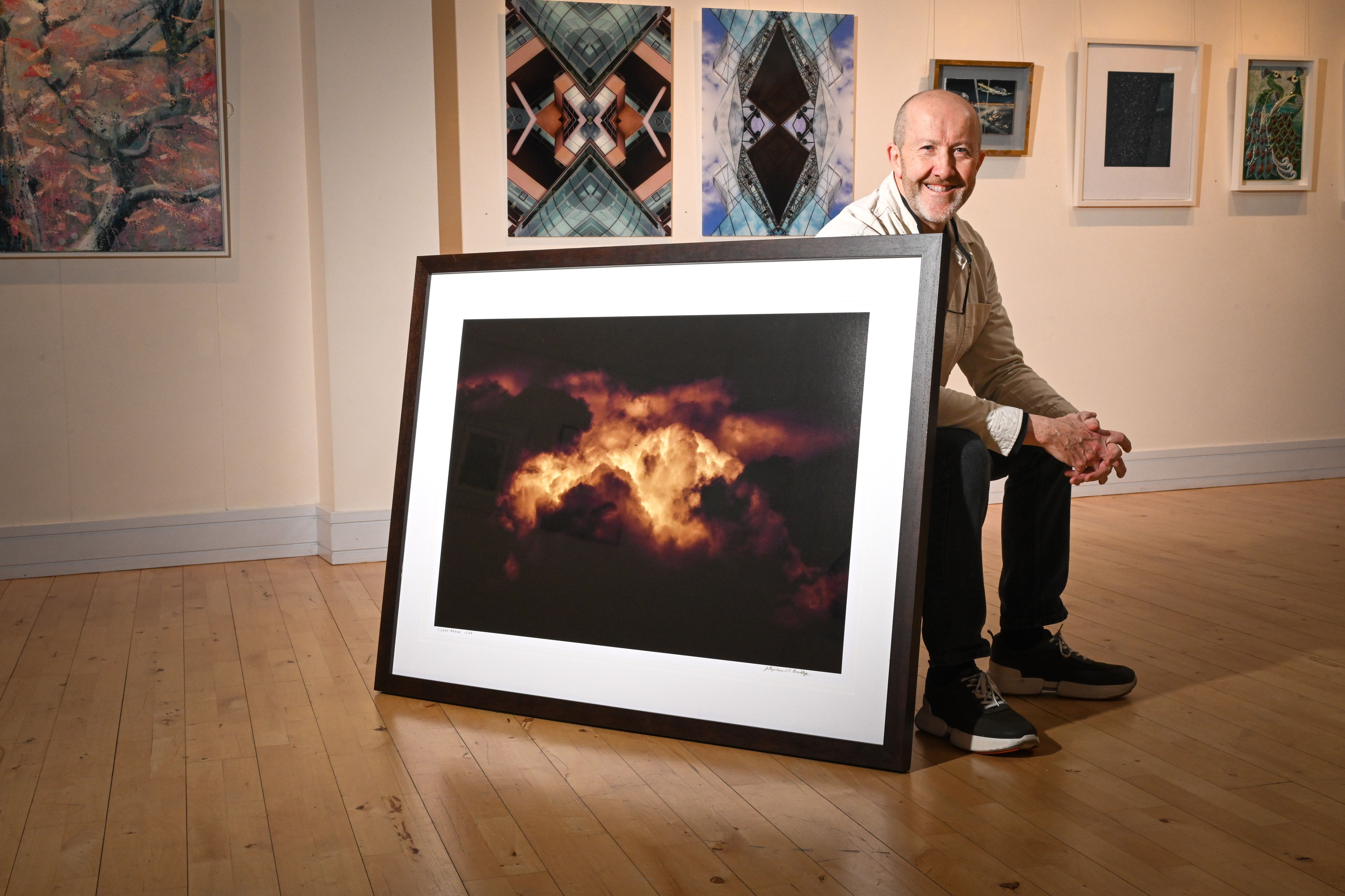 Photographer Stephen S T Bradley, with one of his fine art photographs of Northern Ireland skies