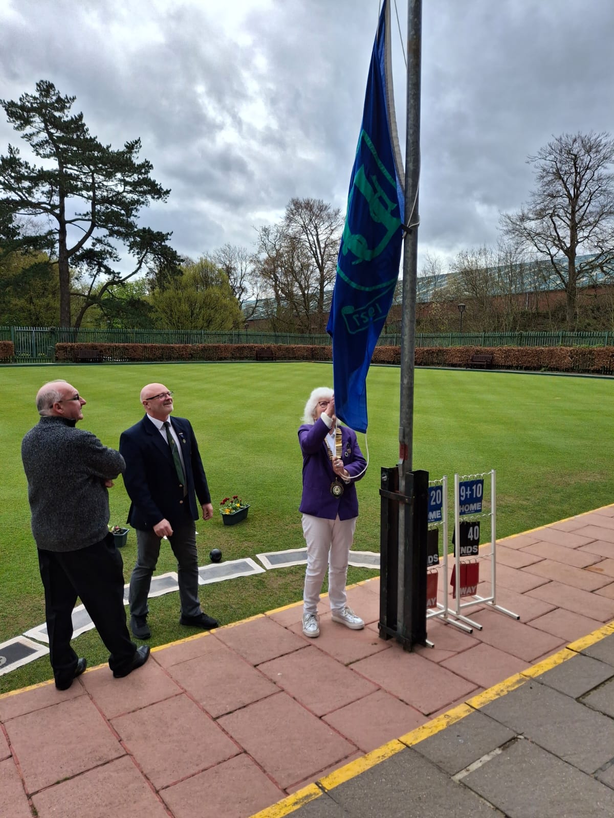 President Elsie Best unfurls the flag