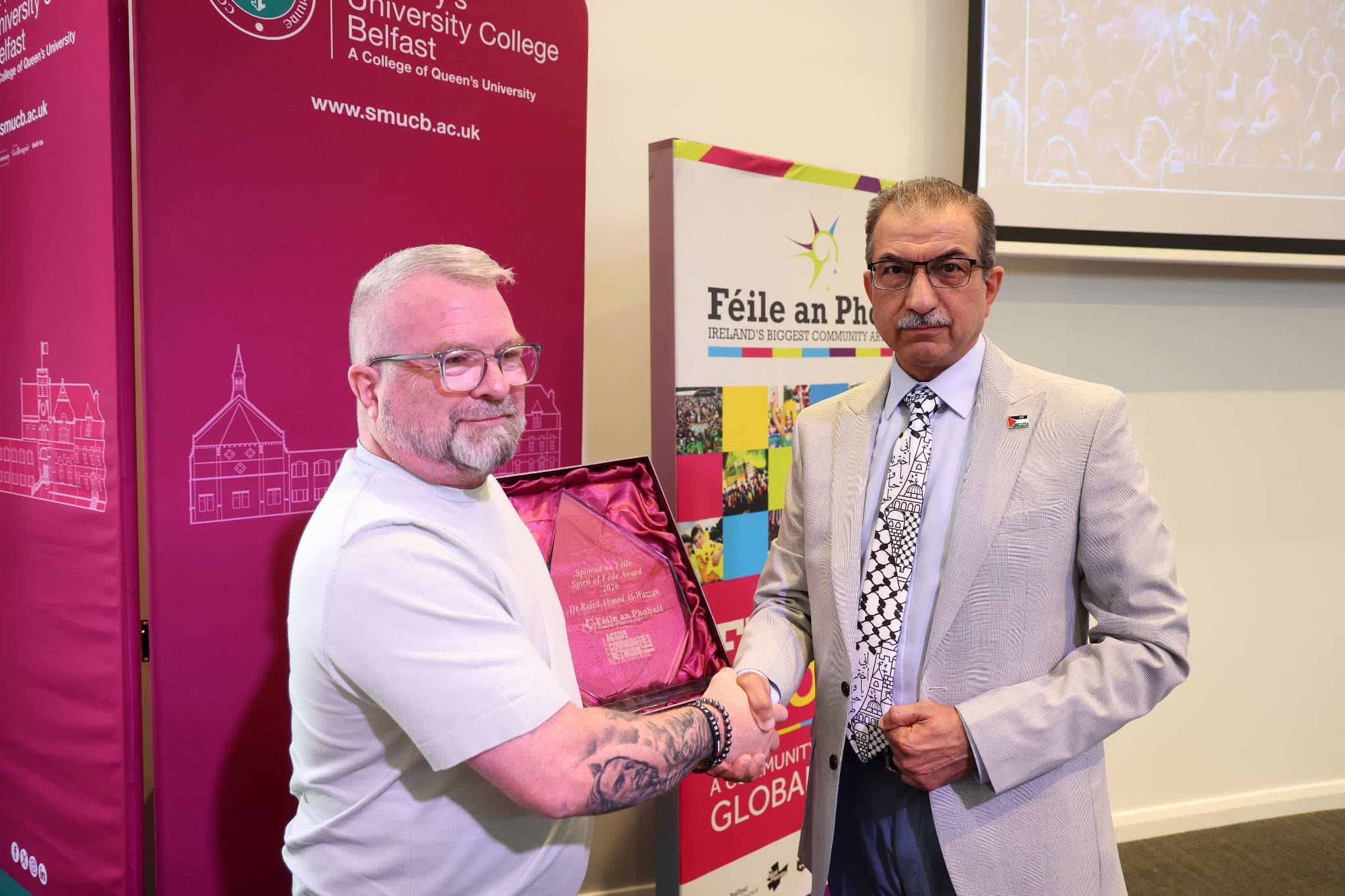 Dr Raied Al-Wazzan is presented with the Spirit of Féile Award by Jim Donnelly from Active Communities Network