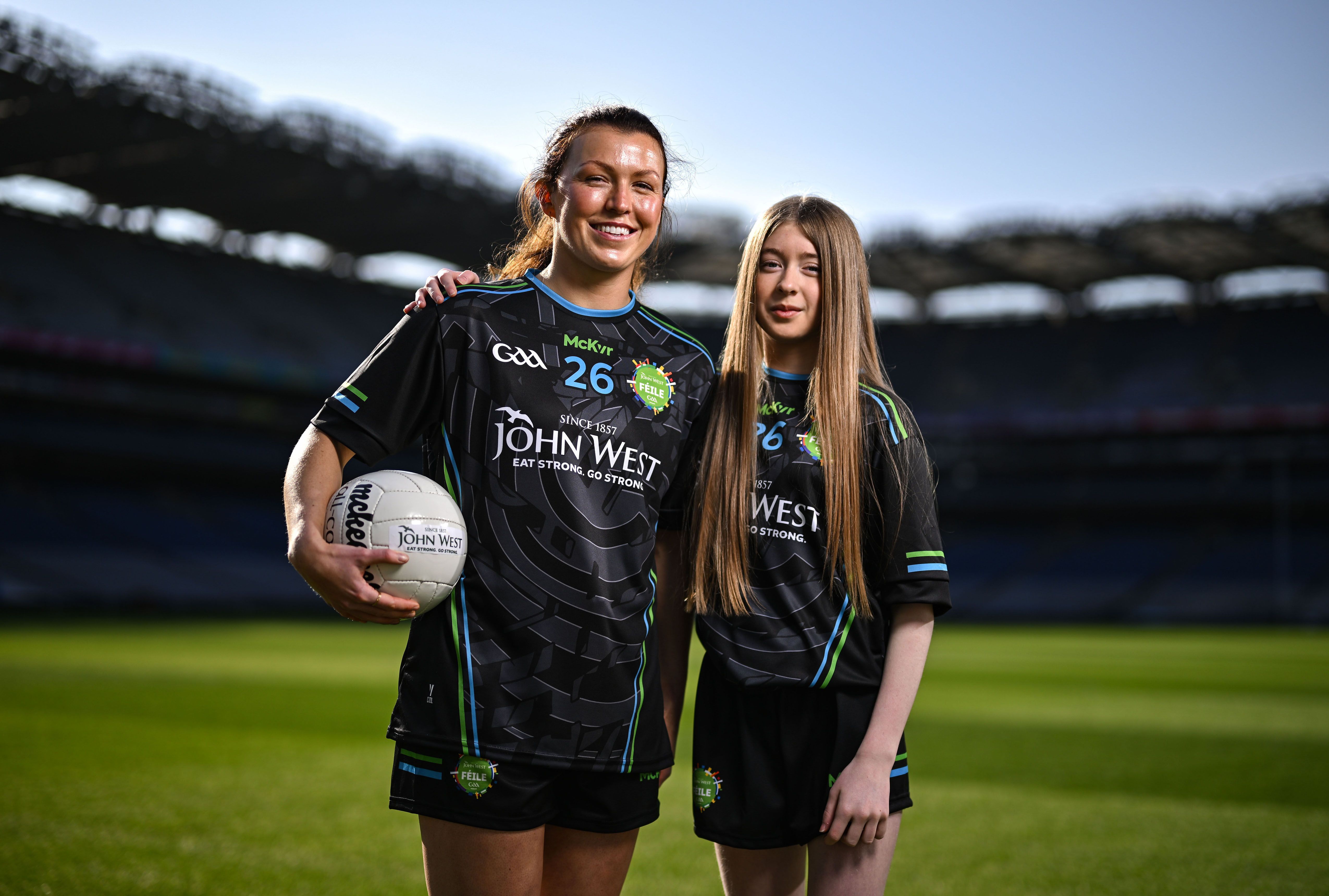 Dublin star Leah Caffrey with U15 O'Tooles footballer Lilly Dunne at Croke Park in advance of the John West Féile Peile na nÓg finals 2026