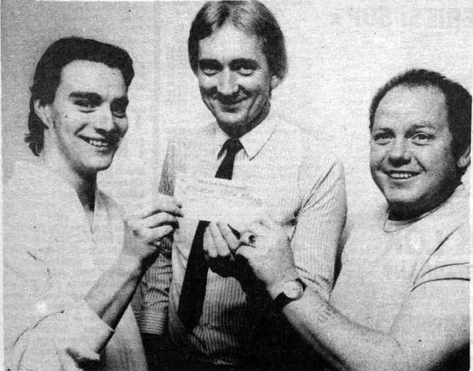 GRAND TOTAL: Pictured with a cheque for the Ethiopian Live Aid Famine Appeal back in July 1985 were the resident DJs at Lámh Dhearg Social Club, Marty McCartney, and Raymond Megaghey who, along with Sid Thompson, raised a staggering £1,050 at their usual Sunday night disco in the Hannahstown clubrooms last weekend