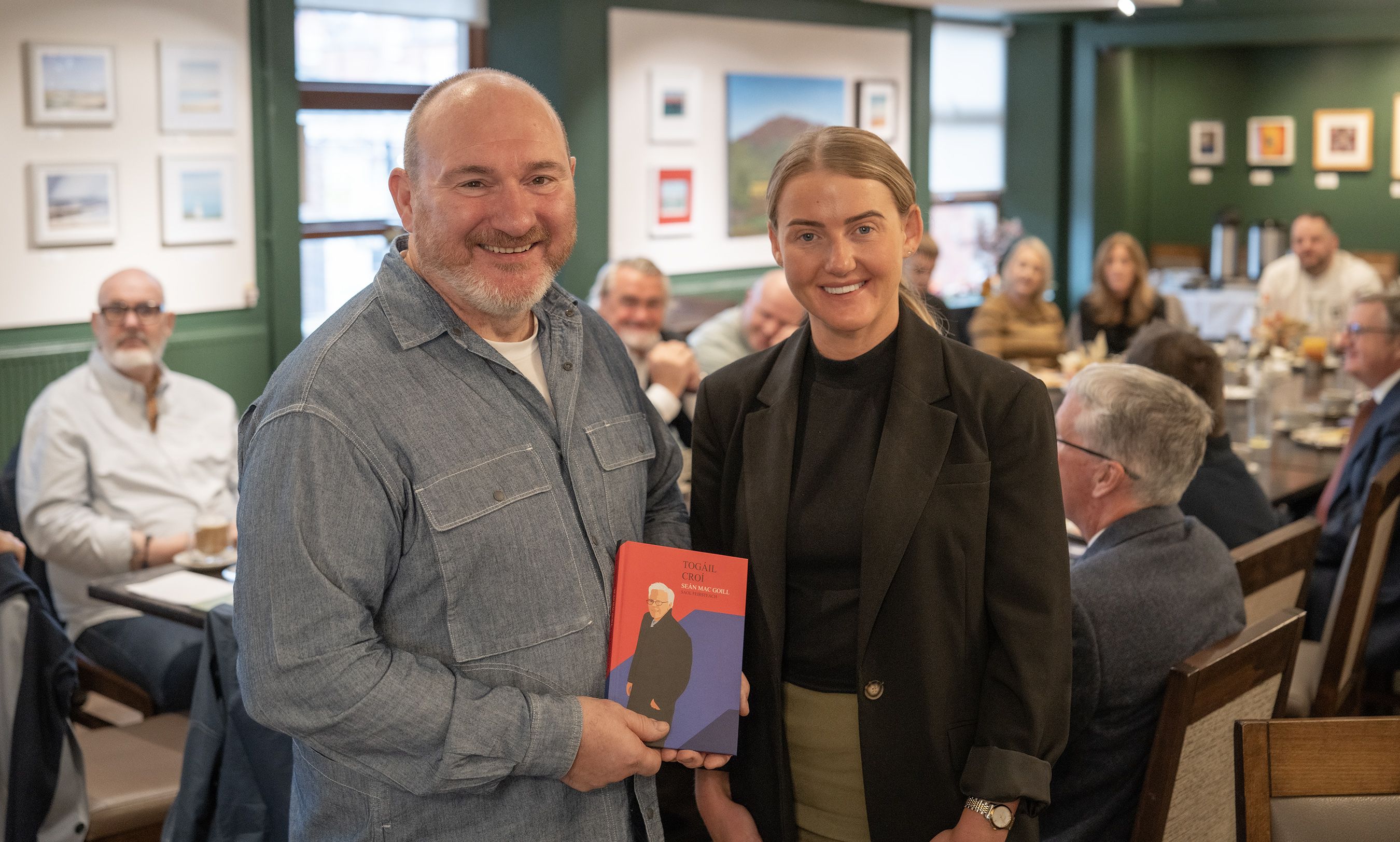NEW CHAPTER: Niall McKenna is presented with a book on Belfast community architect Seán Mackel as a gesture of thanks from the Biz Circle