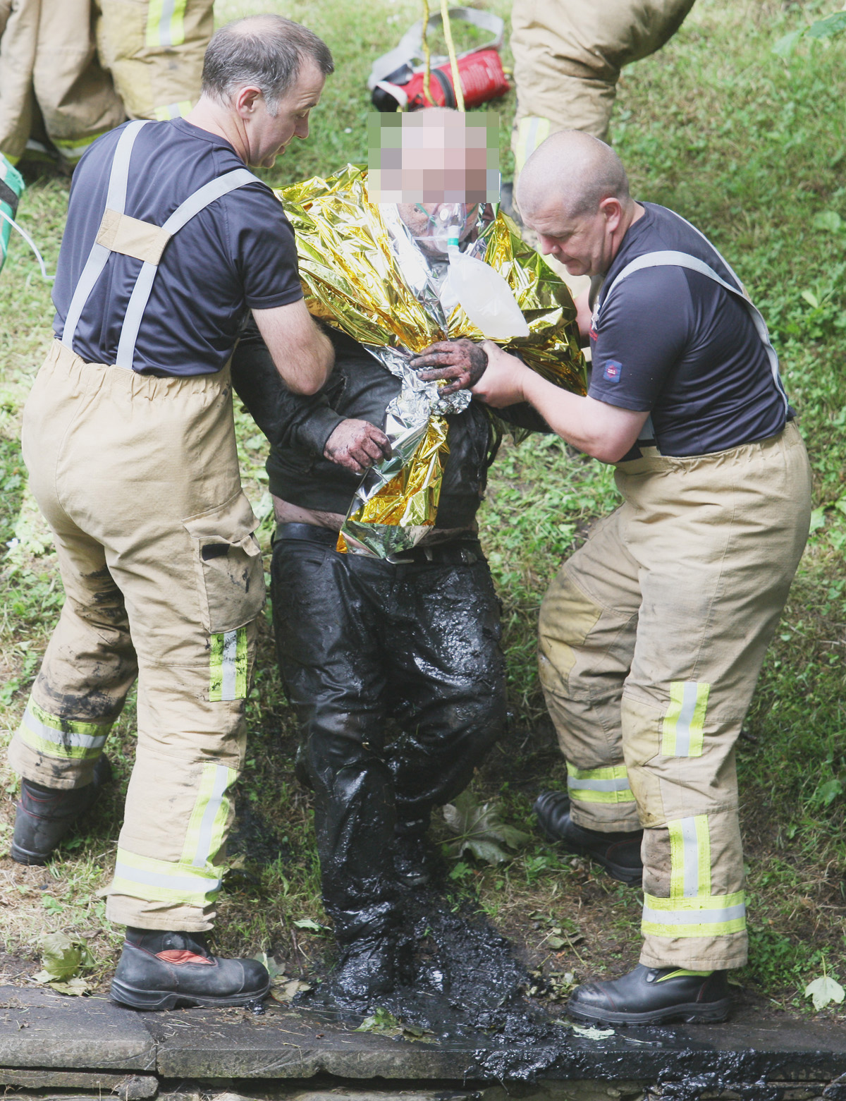 Members of the Fire and Rescue Service with the man who spent four hours trapped in thick mud at the Waterworks