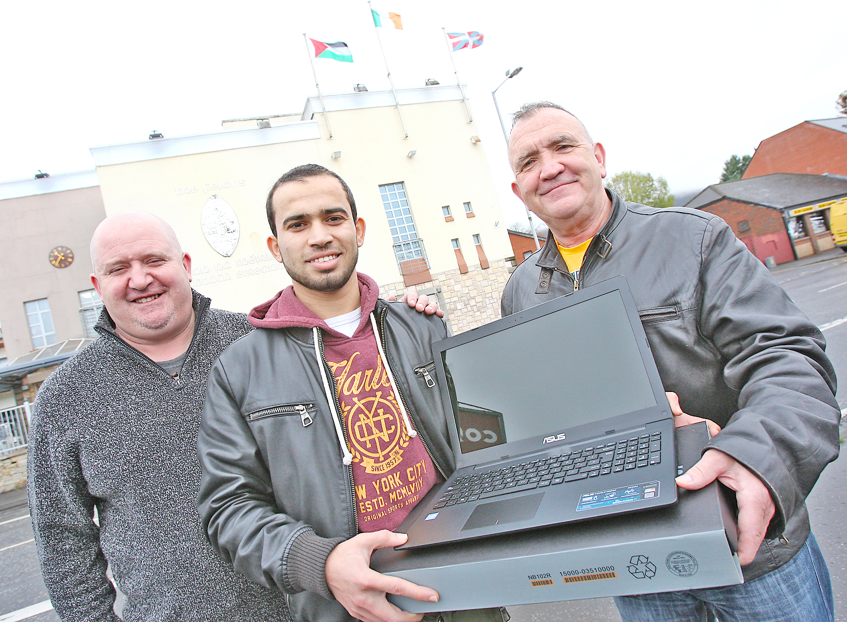 Gerry Scullion of the Felons presents Mustafa Afana from Palestine with a laptop for use in his studies at Queen’s. Looking on is local photographer John Mallon