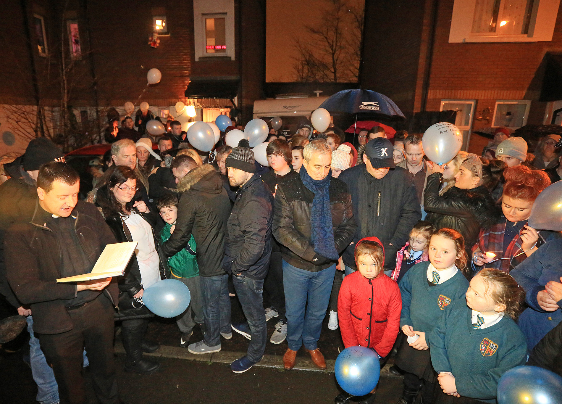 Father Darach Mac Giolla Catháin reads prayers at the vigil; on his left are Christopher\'s parents Chris Meli and Vanessa Burke with one of their younger sons    \nPic by Jim Corr