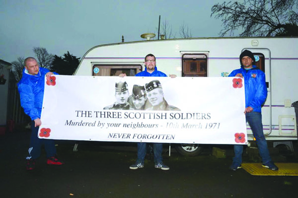 Members of the Regimental Blues hold up a banner to three British soldiers killed in Ligoniel in 1971 at Camp Twaddell