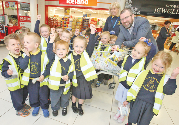 Cathedral Nursery pupils receive goodie bags from Kennedy Centre manager John Jones on their visit to the shopping centre. Also pictured is Principal Una Barr
