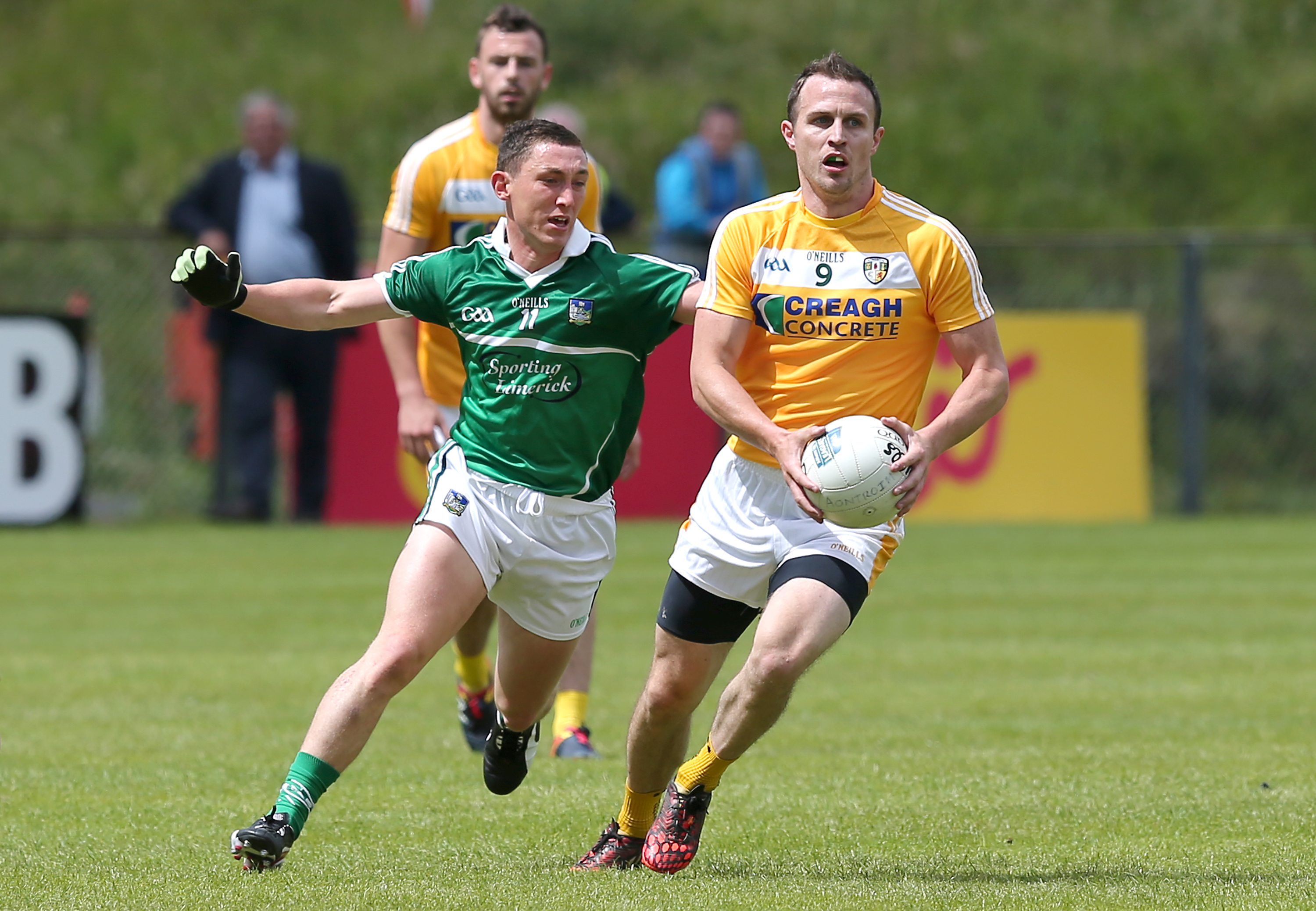 Michael McCann, pictured in action against Limerick’s Peter Nash during Antrim’s Qualifier defeat at Corrigan Park in June, insists he hasn’t retired from inter-county football despite opting off the Saffron squad for the forthcoming season due to work commitments 