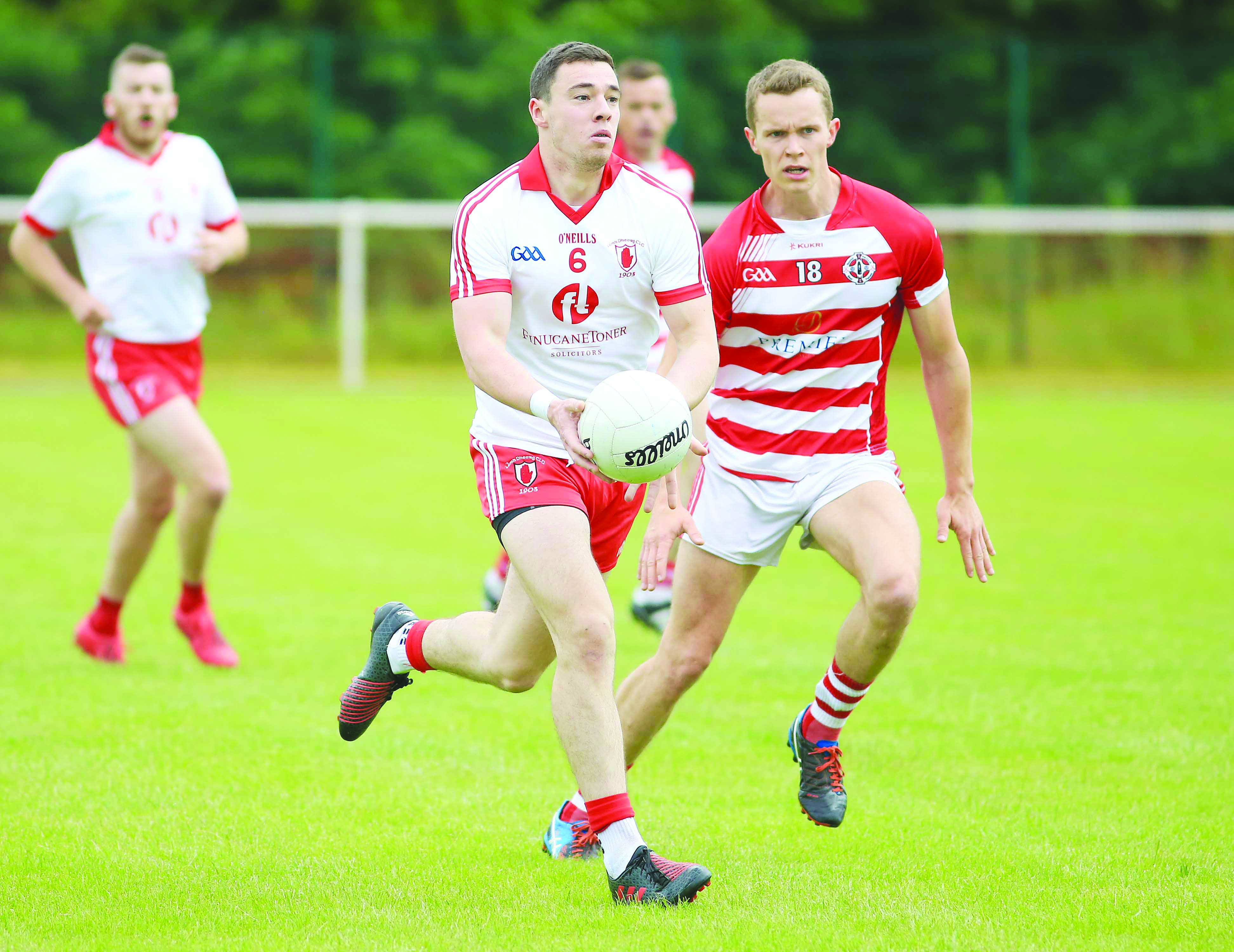 Lámh Dhearg’s Declan Lynch pictured in action against St Paul’s defender Stephen Rooney during their Division One clash earlier this season. The sides meet again in Saturday’s SFC preliminary round clash at Corrigan Park 