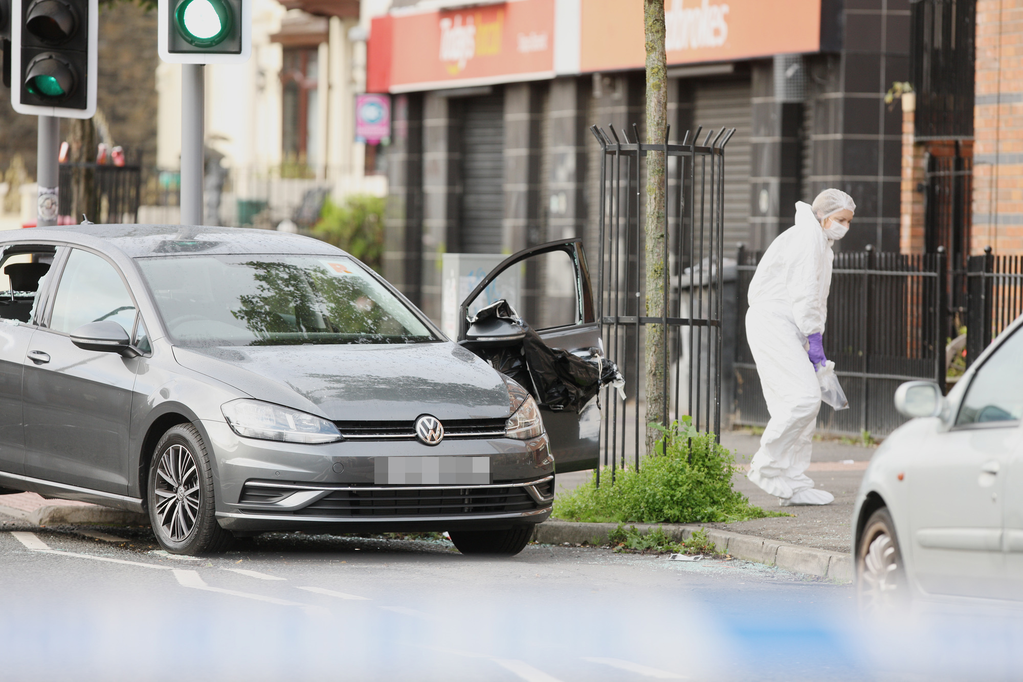 EXPLOSION: A PSNI forensics officer beside the car that was damaged in the pipe bomb attack