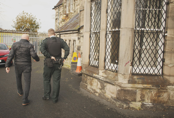 A PSNI officer joins Rev Bill Shaw to survey the damage