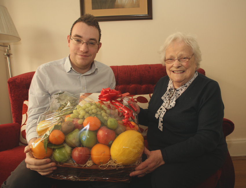 KIND-HEARTED: Conor McParland from the North Belfast News hands over a Christmas hamper to Olive McAlea that was donated by a local businessman\n\n\n\n
