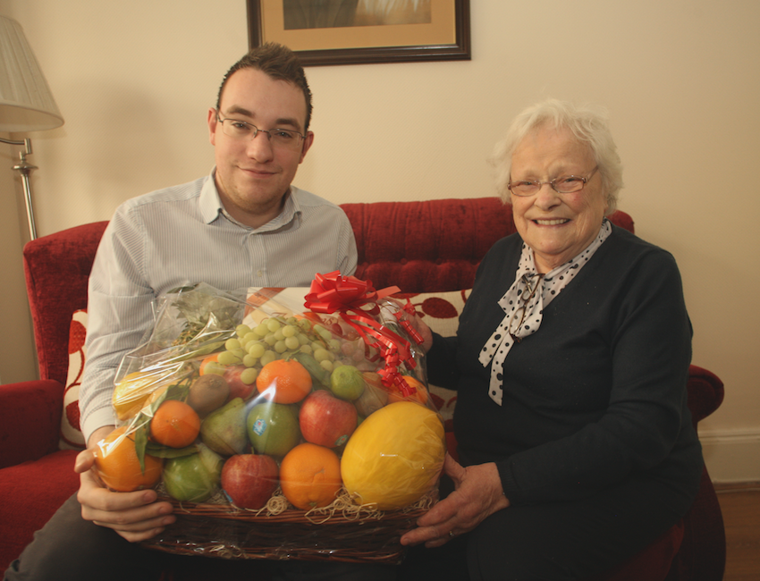 KIND-HEARTED: Conor McParland from the North Belfast News hands over a Christmas hamper to Olive McAlea that was donated by a local businessman\n\n\n\n