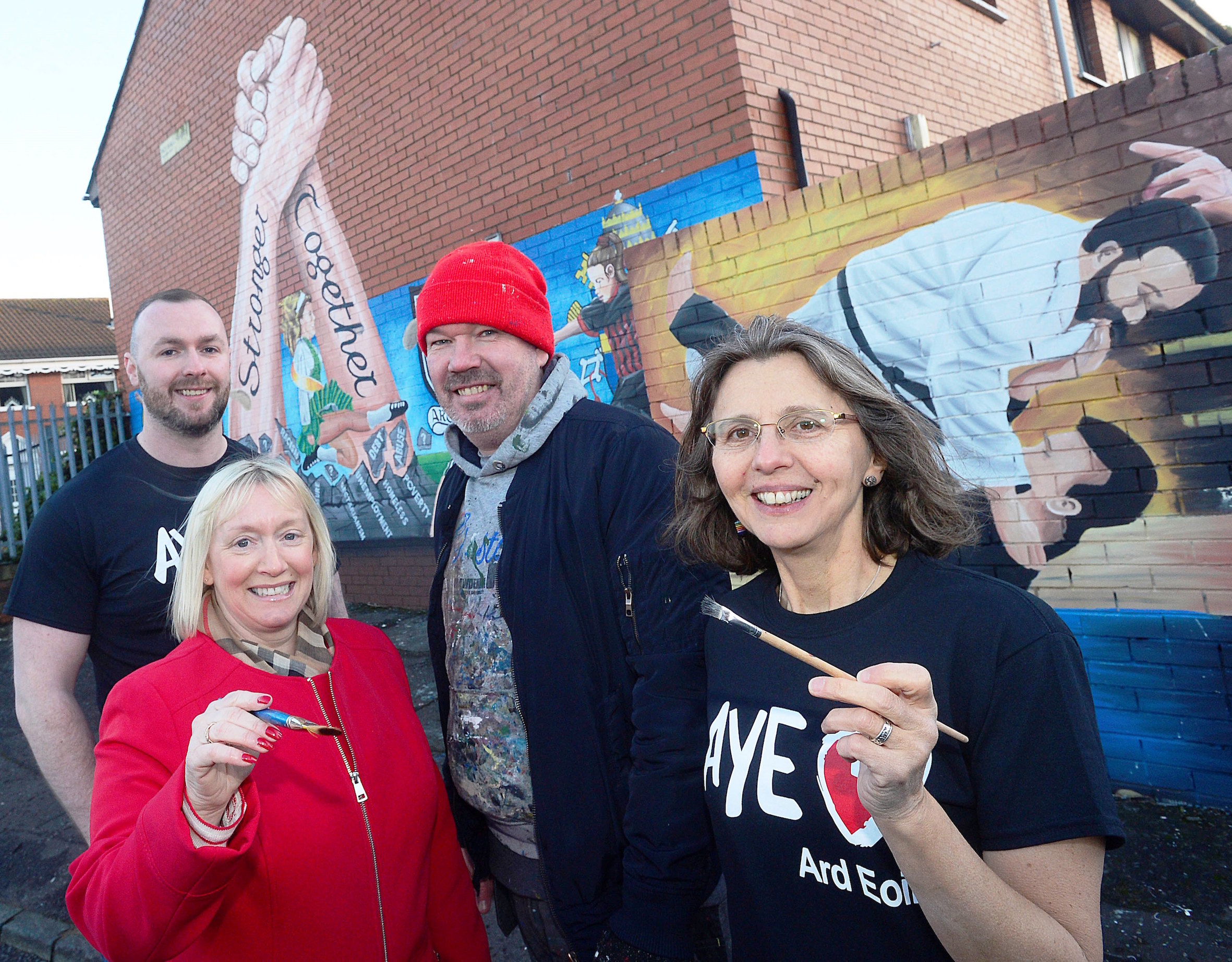 GREAT WORK: Seán Breen (Ardoyne Youth Enterprises Youth Engagement Officer), Amanda Ashe (Housing Executive Community Cohesion Officer), artist Michael Doherty and Catherine Couvert (Ardoyne Youth Enterprise Communications Officer) at the new mural in Havana Court in Ardoyne