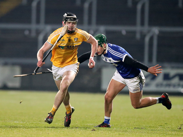 Antrim midfielder Joe Maskey slips away from his opposite number, James Ryan during last Saturday’s  game in Portlaoise. The Saffrons suffered a five-point defeat to Laois and face a huge task this Sunday when they take on Division 1B pacesetters, Limerick in Cushendall 
