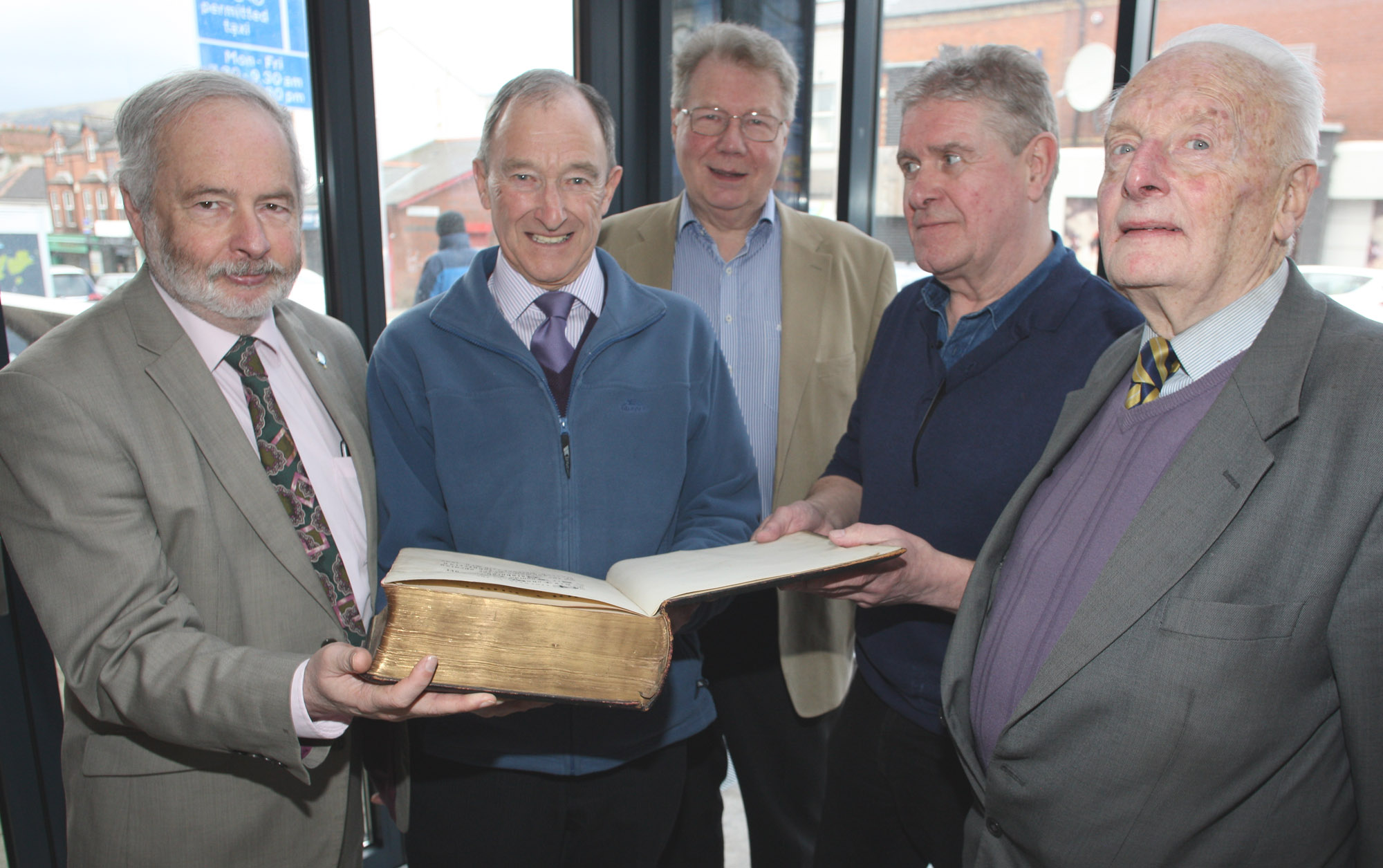 : James E Moffett hands over the Bible from Broadway Presbyterian Church – which is now  An Chultúrlann McAdam Ó Fiaich – to Kevin Shannon, with Very Rev Michael Barry, Derek Alexandar, and Rev Jim Stothers looking on