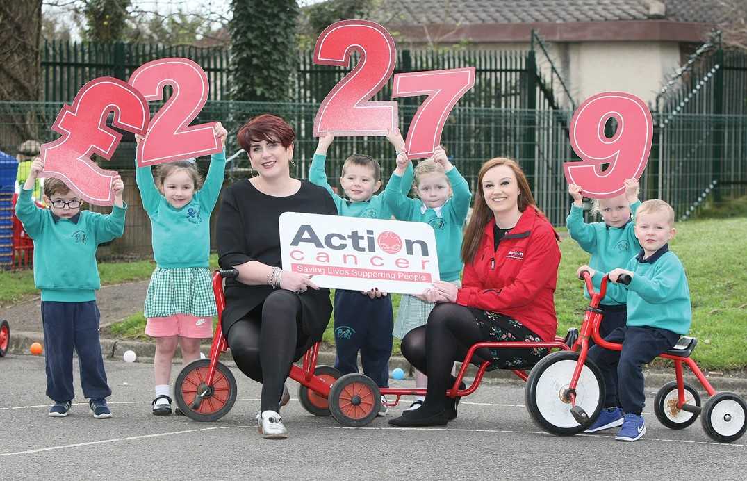 Mrs Clare McAllister, principal of St Michael’s Nursery School, and pupils Ryan Lavery, Aishlinn Killen, David Killyeagh, Niamh O\'Hagan, Orlaith Ferry and Cillian Ferry, present Madeline Knowles, fundraising executive from Action Cancer, with £2,279 after the children participated in a sponsored cycle at their school 