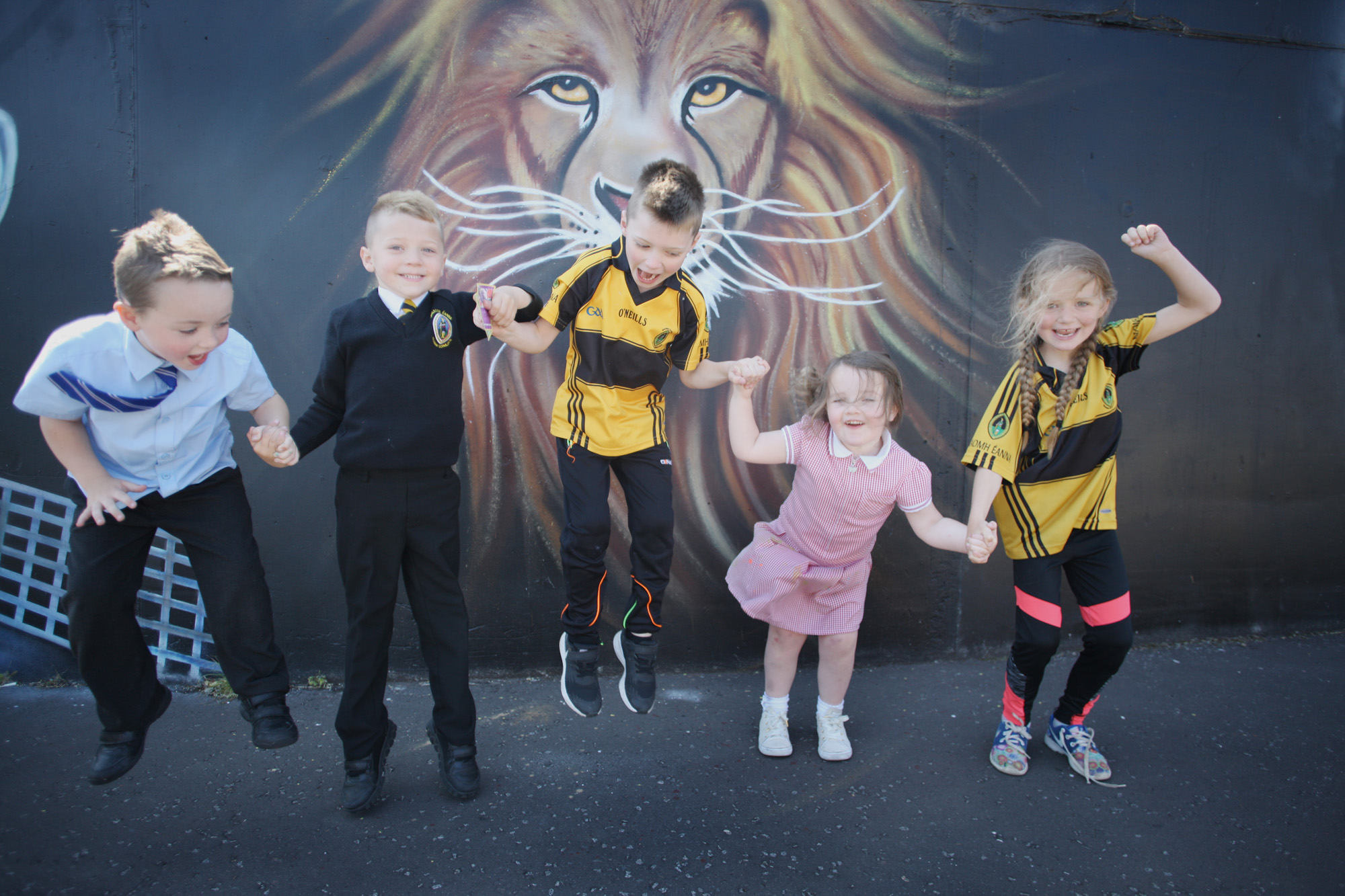 Patrick Hughes, Conláed Hughes, Niamh McConnell, Mason McAdorey and Emily O\'Kane jump for joy at a new mural in Bawnmore Drive in Belfast