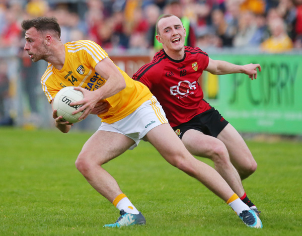 Antrim’s Matthew Fitzpatrick comes under pressure from Down’s Shay Millar during Saturday night’s Ulster SFC clash in Newry. The Saffrons will meet Offaly in the Qualifiers following their seven-point defeat to the Mournemen \n \n