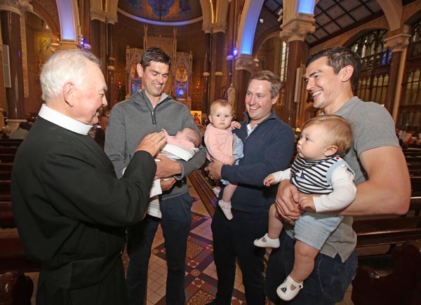 At the Clonard Novena blessing of Babies and Children are Fr John Hanna with Paddy Turley and his one month old daughter Erin, Michael McKeown with his daughter Katey and Matt McManus with his son Finn