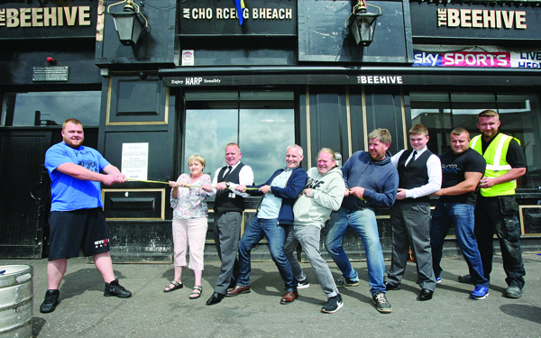 Belfast Strongman Michael Downey holds firm as Jo Fryers of Suicide Awareness, Michael and Christopher Mallon of the Mallon Brothers Funeral Directors, Philip Bannon of the Beehive, Glenn Black and Ken Maze of Blaze FX, Kenny Andrews of Damp Proofing NI and strongman Steven Harrison during the launch of a trial of strength in aid of suicide awareness