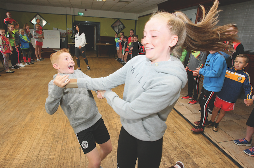 High spirits at Sceim Samhraidh at Lamh Dhearg, featuring Irish classes, mountain walks, art and GAA workshops, Ceili dancing and many other events\nRonan Webb and his sister Orlaith spin down the dance lines at the Ceili.\n