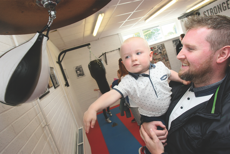 Stephen Agnew and baby John Agnew (grandson of John Dunne) testing out the equipment at the Whiterock Leisure Centre boxing suite in memory of the late John Dunne.