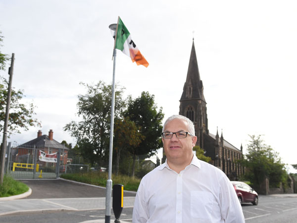 Tim Attwood at the Glen Road spot where the flags have been erected