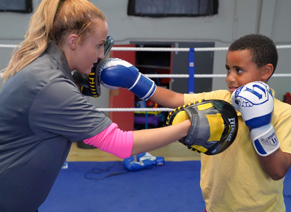 Seconds out: Coach Lauren Leonard puts junior boxer Daniel Mervyn through his paces at Corpus Christi Boxing Club on the Whiterock Road, using equipment funded by the Housing Executive. The club will host the Antrim Amateur Boxing Championships from September 25 to 27
