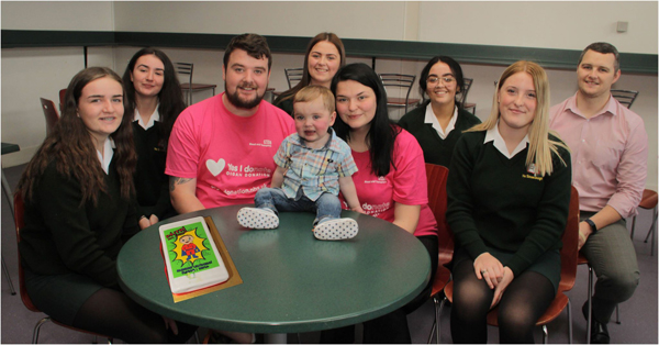 ASSEMBLY STAR: Little Dáithí and his mum and dad with Coláiste Feirste pupils and staff