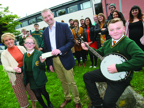 MAITH THÚ: Mike Breen, founder of the Mary\'s Gift Irish Language Foundation, presents a cheque to Catriona Nic an Bheatha and Siomha Nic Bradaigh, while Cian O\'Riordain plays the banjo