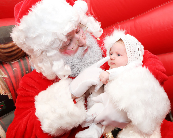 Santa says hello to little Eva Letson (8 weeks old) during his visit to St Teresa\'s parish centre