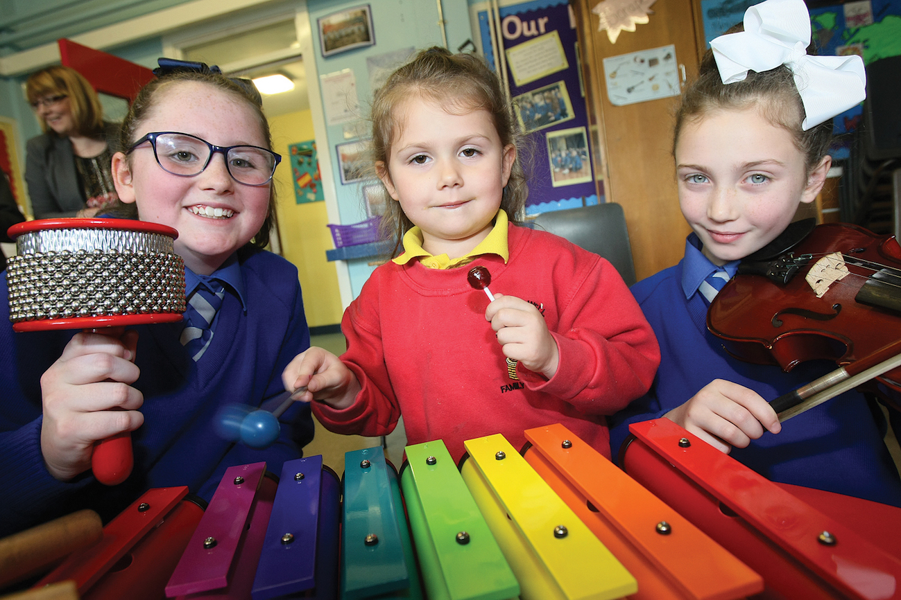 Olivia Kearney and Kiera Fennell introduce Ruby McHale to the xylophone at the Mercy Primary School open day.