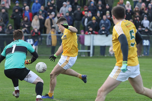 Antrim’s Paddy McBride fires past Derry goalkeeper Thomas Mallon during yesterday’s Allianz Football League clash at Corrigan Park, but it was the Oak Leaf County who claimed the spoils with a dramatic injury-time winner 