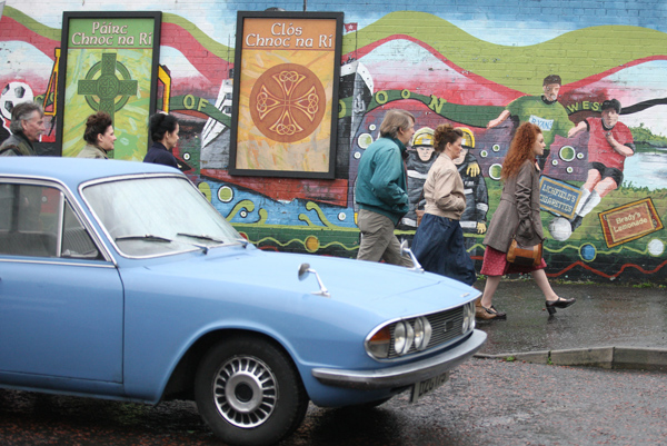 Extras walk past a classic 1968 Triumph 2000 MK2 during filming for the BBC\'s Dublin Murders in Lenadoon this week