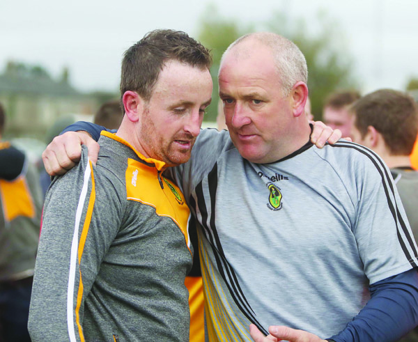 Naomh Éanna midfielder Philly Curran and manager Frank Fitzsimons embrace following the county final win over Gort na Móna 
