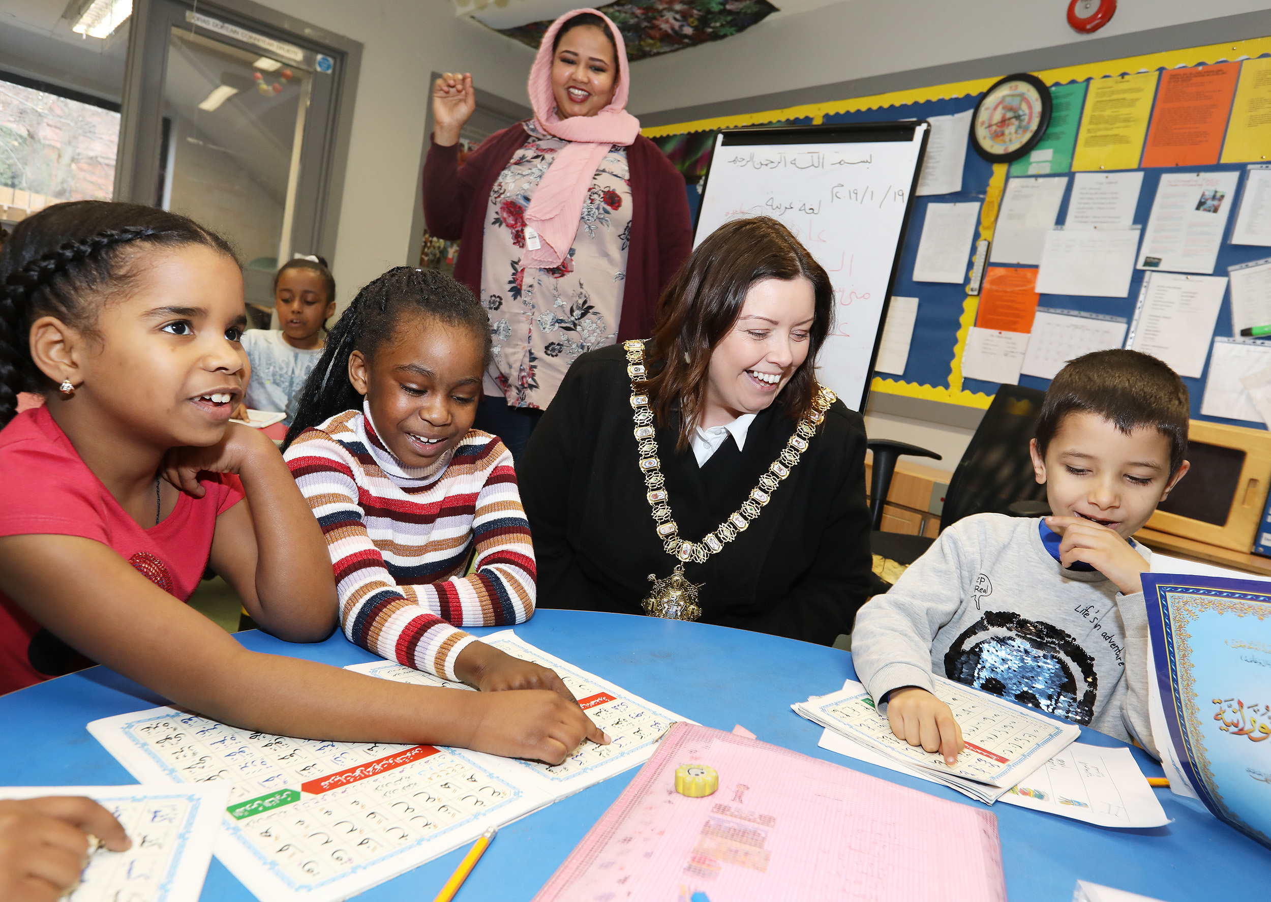 Lord Mayor Deirdre Hargey joins a class at the An Droichead, Sudanese Saturday School with students Mona, Sireen and Ali Saad, and teacher Mohga Salih 