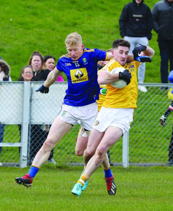 Antrim’s Ryan Murray comes under pressure from Wicklow’s Mark Kenny during Saturday’s Division Four clash at Corrigan Park  