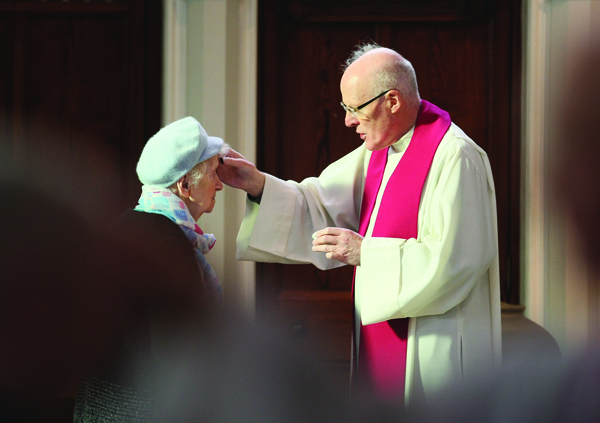 Father Peter Burns gives out ashes during Mass at Clonard Monastery on Ash Wednesday